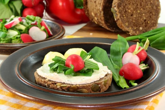 a slice of bread topped with cream cheese and fresh wild garlic