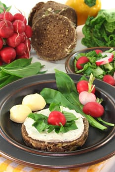 a slice of bread topped with cream cheese and fresh wild garlic