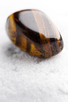 Natural stone tiger iron shines in beautiful colors on a white background