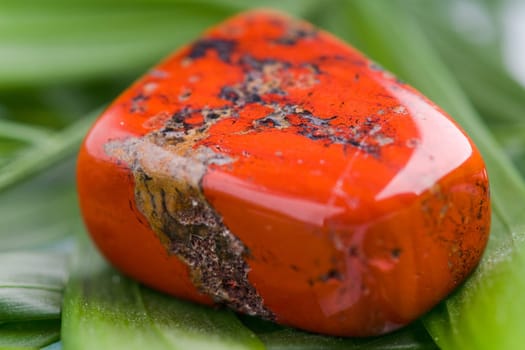 Natural stone red jasper shines in beautiful colors on a white background