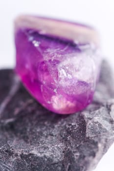 Natural stone amethyst shines in beautiful colors on a white background