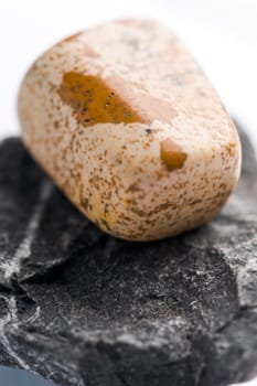 Natural stone jasper shines in beautiful colors on a white background