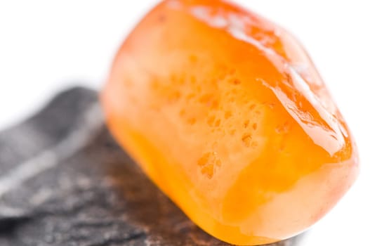 Natural stone carnelian shines in beautiful colors on a white background