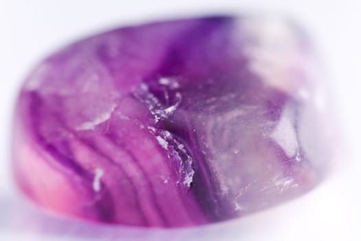 Natural stone amethyst shines in beautiful colors on a white background