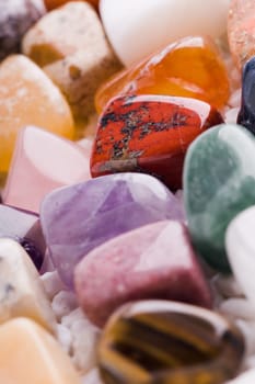 Many different natural stones in beautiful colours on a white background