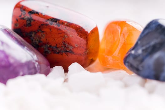 Many different natural stones in beautiful colours on a white background
