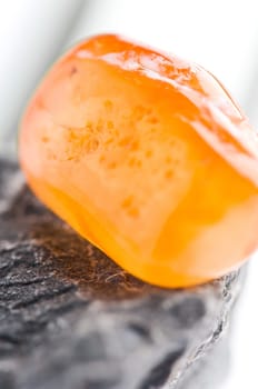 Natural stone carnelian shines in beautiful colors on a white background
