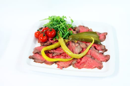 Roastbeef with gherkin and hot pepper on white background