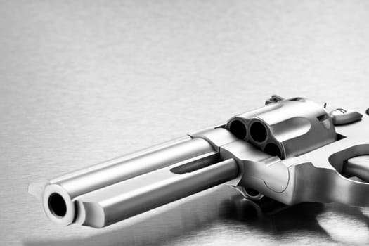 handgun on steel background - modern revolver closeup with copyspace. Focus on cylinder.