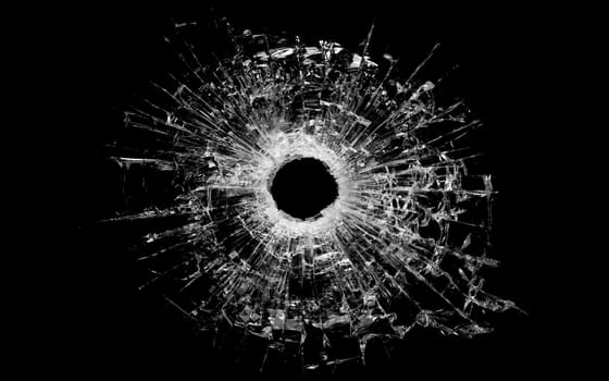 bullet hole in glass - real bullet hole closeup and isolated on black