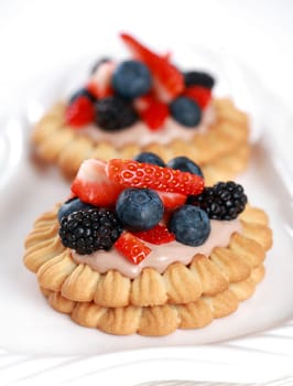Delicious cookies with chocolate cream and fresh berries