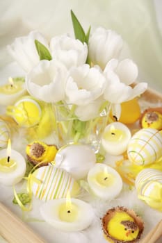 Table decoration for Easter with eggs and white tulips