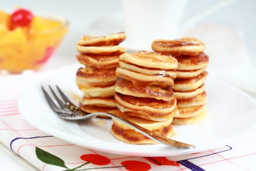 Sweet pancakes with compote and pancake maker background