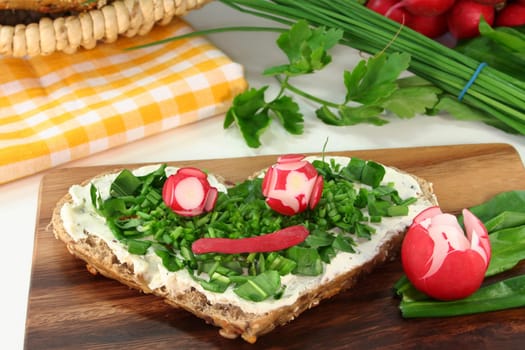 a roll topped with cream cheese,chives and fresh wild garlic