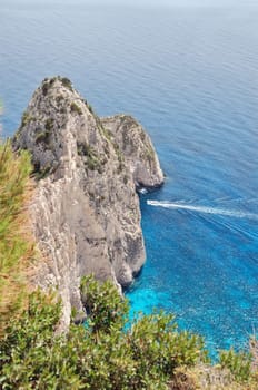 View to the ionian sea and small boat cruising through the Myzithres rocks. Zakynthos, Greece.