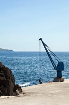 Port crane in a small harbor, Pico, Azores