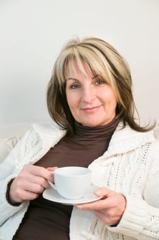 Portrait of a middle-aged woman holding a white coffee cup