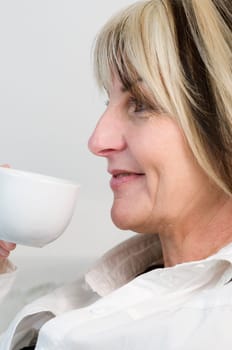 Portrait of a middle-aged woman holding a white coffee cup