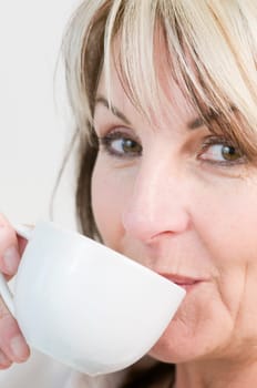 Portrait of a middle-aged woman holding a white coffee cup