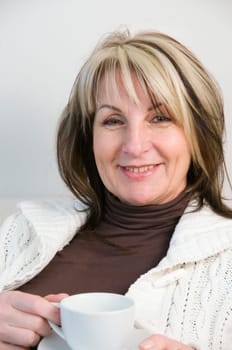 Portrait of a middle-aged woman holding a white coffee cup