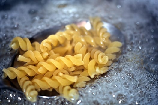Fusilli pasta italian food cooked in boiling water. Selective focus.