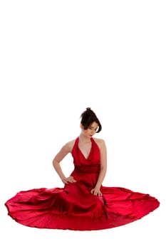 Young pretty woman in red evening dress sitting on the floor