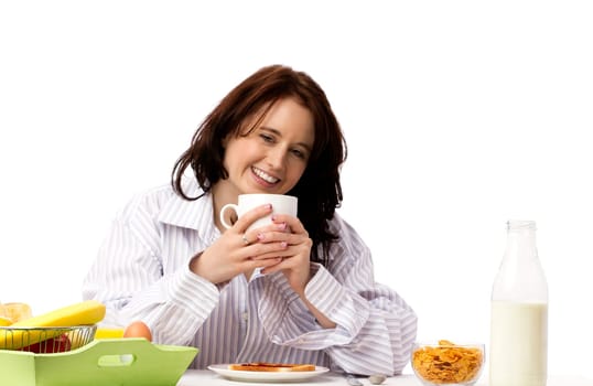 Young laughing woman holding coffee cup at breakfast