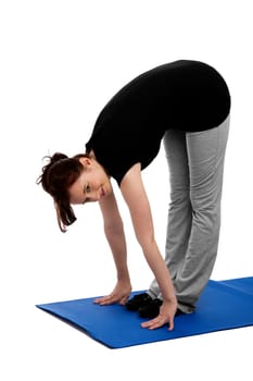 Young woman exercising trunk bends on a blue yoga mat
