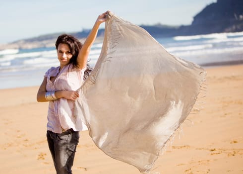 a young pretty girl with a scarf in a beach in a sunny beach