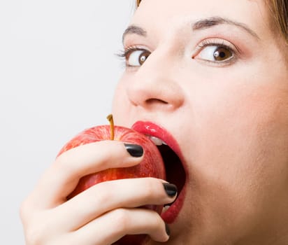 a young pretty girl eating a fresh healthy red apple