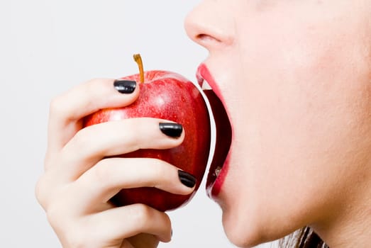 a young pretty girl eating a fresh healthy red apple