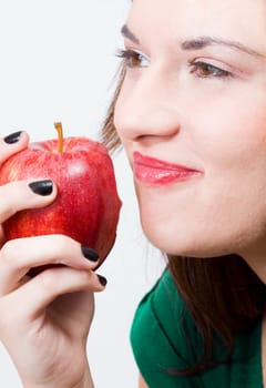 a young pretty girl eating a fresh healthy red apple