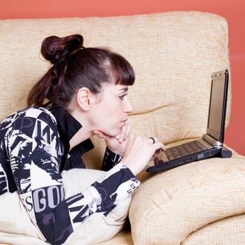 a real young woman typing in the keypad of a laptop