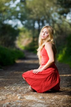 beautiful young girl with a red dress in the nature