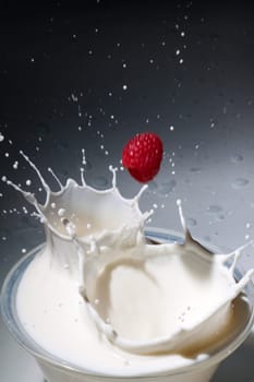 Raspberries fall into milk