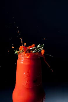 Tomatoes fall into a bottle of tomato juice