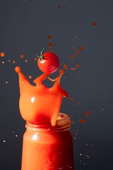 Tomatoes fall into a bottle of tomato juice