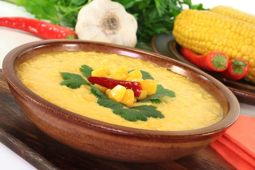 a bowl of corn soup with chili and coriander