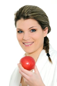 Young beautiful woman in bathrobe eating an apple
