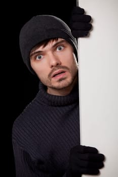 surprised burglar looking behind the door