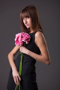 fashion woman with flowers posing over grey background