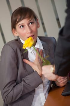 Man giving rose as a gift to a female office worker
