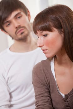 couple in conflict - sad woman and unhappy man at home