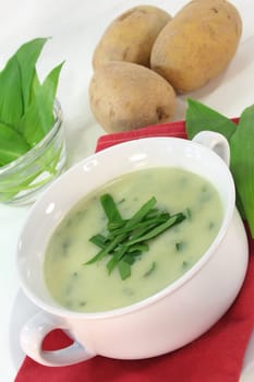 a bowl of wild garlic soup with fresh wild garlic