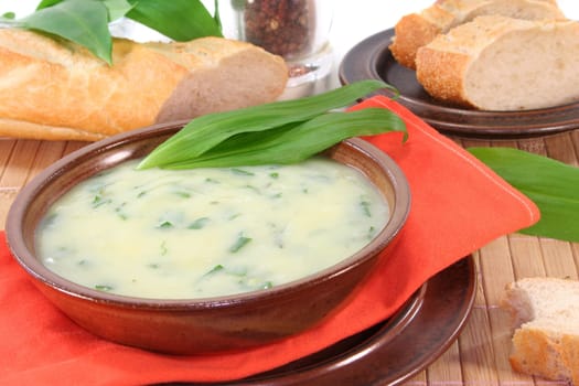 a bowl of wild garlic soup with fresh wild garlic