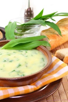 a bowl of wild garlic soup with fresh wild garlic