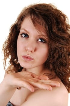 The beautiful smiling face of a young woman in closeup, blowing a kiss, with her nice blue eyes, on white background.