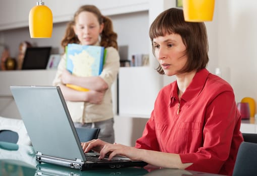 Mother and teenager girl with laptop computer together at home