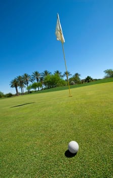 Image of a golf ball ongreen with flag
