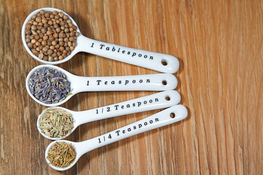 Old table-top selection of herbs and grains in measuring spoons